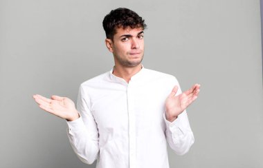 Adam şaşkın ve şaşkın hissediyor, doğru cevap ya da karardan emin değil, bir seçim yapmaya çalışıyor.