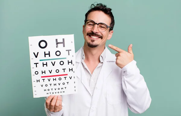 adult man smiling confidently pointing to own broad smile. optical vision test concept