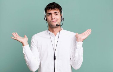 Yetişkin bir adam kafasının karıştığını ve kulaklıkla kuşkulandığını hissediyor. tele pazarlamacı konsepti