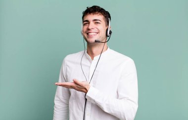 Yetişkin bir adam neşeyle gülümser, mutlu hisseder ve kulaklıkla bir konsept gösterir. tele pazarlamacı konsepti