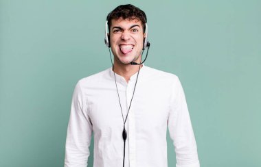 Yetişkin bir adam tiksinti ve tedirginlik duyuyor ve kulaklıkla dilini çıkarıyor. tele pazarlamacı konsepti