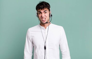 Yetişkin bir adam kulaklıkla şaşkın ve kafası karışmış hissediyor. tele pazarlamacı konsepti