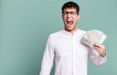Yetişkin bir adam agresif bir şekilde bağırıyor, çok sinirli görünüyor. Dolar banknotları konsepti