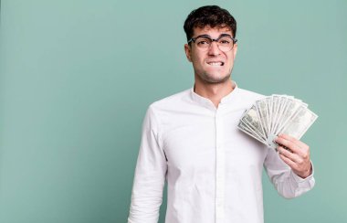 Yetişkin adam şaşkın ve şaşkın görünüyor. Dolar banknotları konsepti