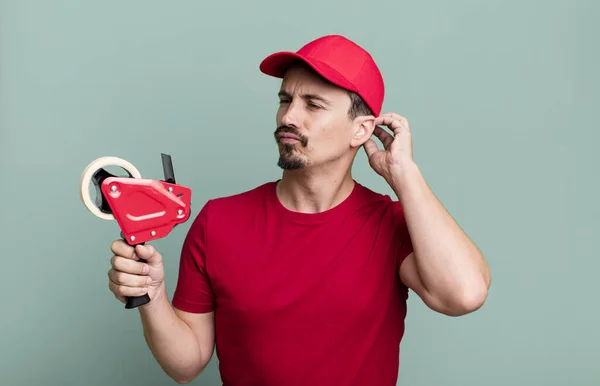 Adult Man Feeling Puzzled Confused Scratching Head Deliveryman Packer Concept — Stockfoto