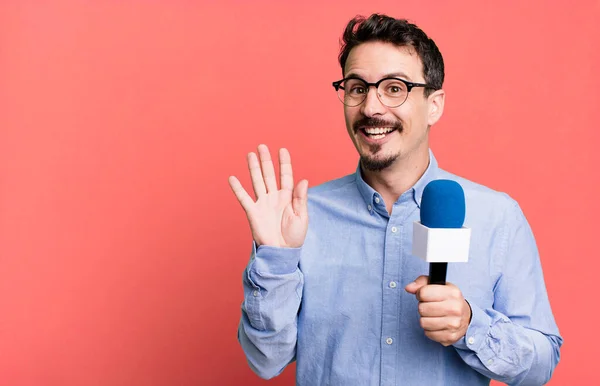Adult Man Smiling Happily Waving Hand Welcoming Greeting You Microphone — Stockfoto