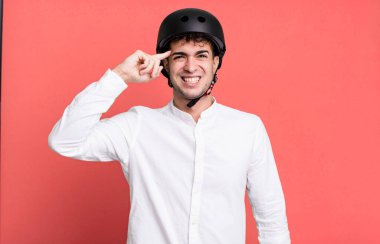 Yetişkin bir adam kafası karışık ve şaşkın hissediyor, senin deli olduğunu gösteriyor. şehir motosiklet sürücüsü konsepti