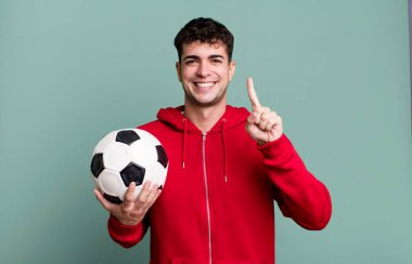 Yetişkin bir adam gülümsüyor ve arkadaş canlısı görünüyor. Bir numarayı gösteriyor. futbol ve spor konsepti