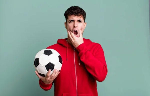 adult man with mouth and eyes wide open and hand on chin. soccer and sport concept