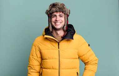 Yetişkin adam şaşkın ve kafası karışmış, anorak giymiş, kaşınan bir kafa. kış ve soğuk konsept