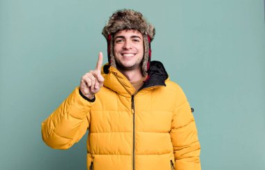 Yetişkin bir adam gülümsüyor ve dost canlısı görünüyor. Bir numara anorak giyiyor. kış ve soğuk konsept