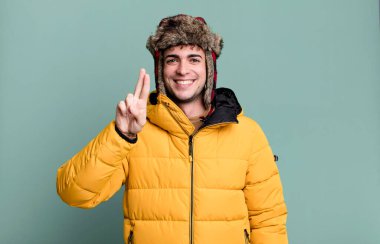 İki numaranın anorak giydiğini gösteren gülümseyen ve arkadaş canlısı görünen yetişkin bir adam. kış ve soğuk konsept