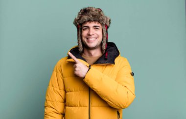 Yetişkin bir adam heyecanlı ve anorak giydiği için şaşırmış görünüyor. kış ve soğuk konsept