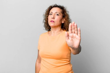 Orta yaşlı İspanyol bir kadın ciddi, sert, hoşnutsuz ve kızgın görünüyor.