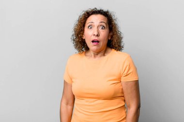 Orta yaşlı İspanyol bir kadın şok olmuş ya da şaşırmış görünüyor, ağzı açık bir şekilde 