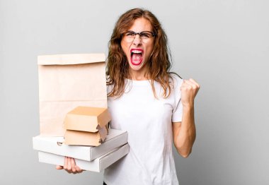 İspanyol güzel kadın sinirli bir ifadeyle agresif bir şekilde bağırıyor. Fast food paketleri kavramını kaldır