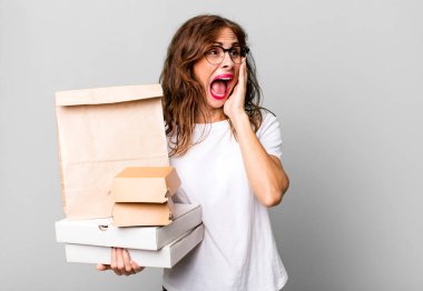 hispanic pretty woman feeling happy, excited and surprised. take away fast food packages concept