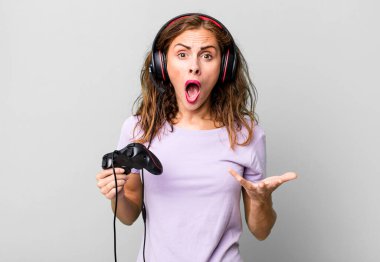 hispanic pretty woman amazed, shocked and astonished with an unbelievable surprise. gamer concept