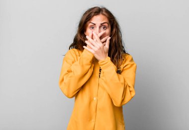 İspanyol asıllı güzel bir kadın elleri ile ağzını kapatıyor. suçluluk duygusu