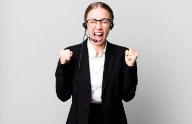 caucasian pretty woman shouting aggressively with an angry expression. telemarketing concept