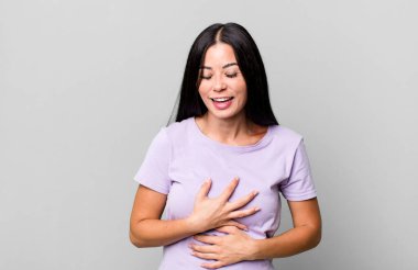 Güzel Latin bir kadın komik bir şakaya yüksek sesle gülüyor, mutlu ve neşeli hissediyor, eğleniyor.