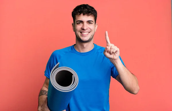 Dospělý Muž Usmívá Vypadá Přátelsky Ukazuje Číslo Jedna Fitness Jóga — Stock fotografie