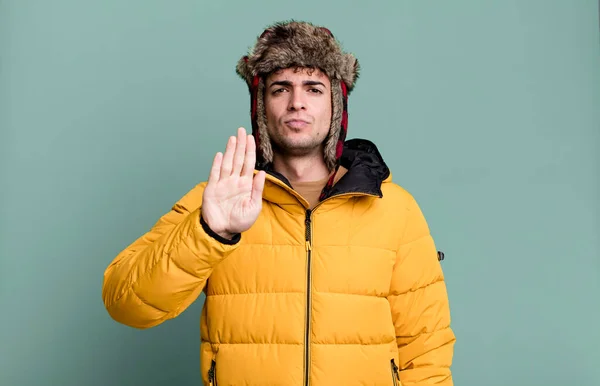 一个看起来很严肃的男人 穿着风衣 展示着张开的手心 做出停止姿势 冬季和寒冷的概念 — 图库照片