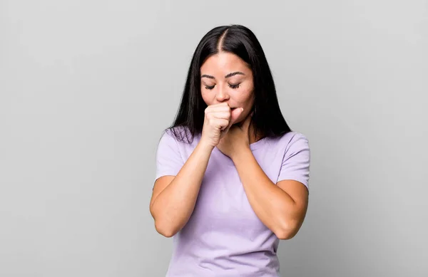 喉の痛みやインフルエンザの症状に悩まされているラテン系の女性は口を覆い咳をし — ストック写真
