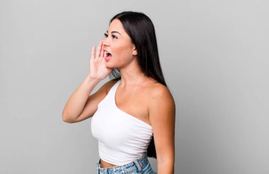 Güzel Latin kadın profil görüntüsü, mutlu ve heyecanlı görünüyor, bağırıyor ve kenarda yer kopyalamak için arıyor.