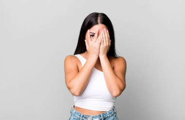 Güzel Latin bir kadın korkmuş ya da utanmış hissediyordu. Gözleri yarı kapalı, yarı çıplak bir şekilde dikizliyordu.