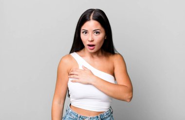 Güzel Latin bir kadın şaşkın ve şaşırmış hissediyor, gülümsüyor, el ele tutuşuyor, o olmaktan mutlu ya da minnettarlık gösteriyor.