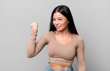 Güzel Latin bir kadın kendini mutlu, tatmin olmuş ve güçlü hissediyor, kaslı ve formda, spor salonundan sonra güçlü görünüyor.