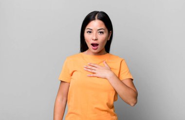 Güzel Latin bir kadın şok olmuş, şaşırmış ve şaşırmış hissediyor, elleri göğsünde ve ağzı açık, kim olduğunu söylüyor, ben mi??