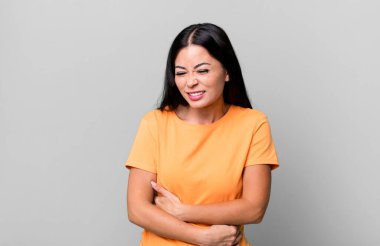 Güzel Latin bir kadın endişeli, hasta, hasta ve mutsuz hissediyor. Ağrılı bir mide ağrısı veya grip geçiriyor.