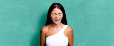 Güzel Latin bir kadın agresif bir şekilde bağırıyor, çok kızgın, sinirli, öfkeli ya da sinirli görünüyor.