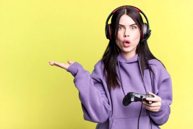 Kulaklık takan genç bir kadın joystick 'te video oyunu oynuyor.