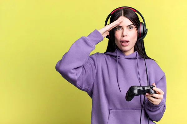 ジョイスティックでビデオゲームをするヘッドフォンを着ている若い女性 — ストック写真