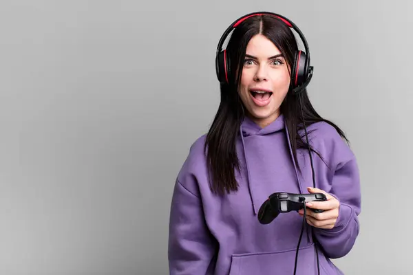 年轻女子戴着耳机在操纵杆上玩电子游戏 — 图库照片