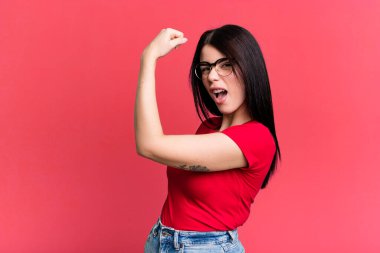 Genç ve güzel bir kadın kendini mutlu, tatmin olmuş ve güçlü hissediyor, kaslı ve formda, spor salonundan sonra güçlü görünüyor.