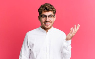 young adult caucasian man feeling happy, surprised and cheerful, smiling with positive attitude, realizing a solution or idea