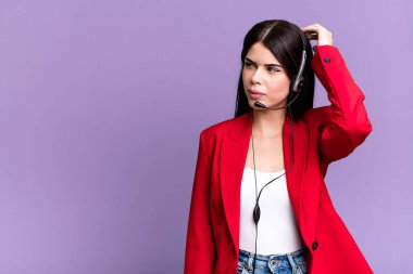 Mutlu bir şekilde gülümsemek ve hayal kurmak ya da şüphe etmek. Kulaklık takan bir pazarlamacı.