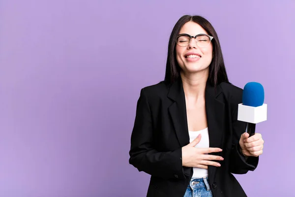 stock image laughing out loud at some hilarious joke. journalist or presenter with a micro