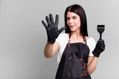 Gülümsüyor ve arkadaş canlısı görünüyor, beş numarayı gösteriyor. kuaför konsepti