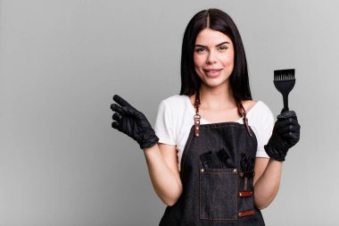 Neşeli bir şekilde gülümsüyor, mutlu hissediyor ve bir tarafı işaret ediyor. kuaför konsepti