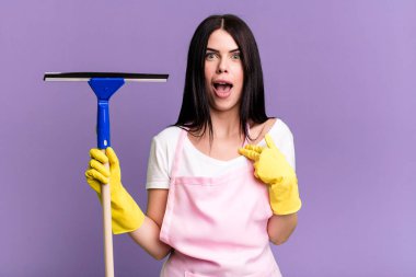 Şok olmuş ve ağzı açık, kendini işaret ederek şaşırmış görünüyordu. Pencere temizleme kavramı