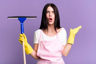 Şaşırmış ve şok olmuş bir şekilde, çenesi düşmüş bir şekilde elinde bir nesne tutarken. Pencere temizleme kavramı