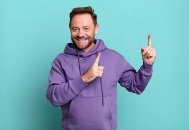 Gülümseyen ve her iki elinle yukarı ve yana doğru gösteren nesne kopyalama boşluğunda