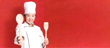 Genç, güzel, Asyalı bir kadın. Ahşap aletli restoran şefi.