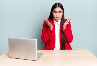 Güzel Asyalı kadın çok şaşırmış ve şok olmuş hissediyor. iş masası konsepti