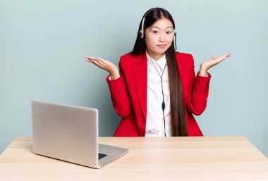 Güzel Asyalı kadın şaşkın, şaşkın ve şüpheci hissediyor. iş masası konsepti